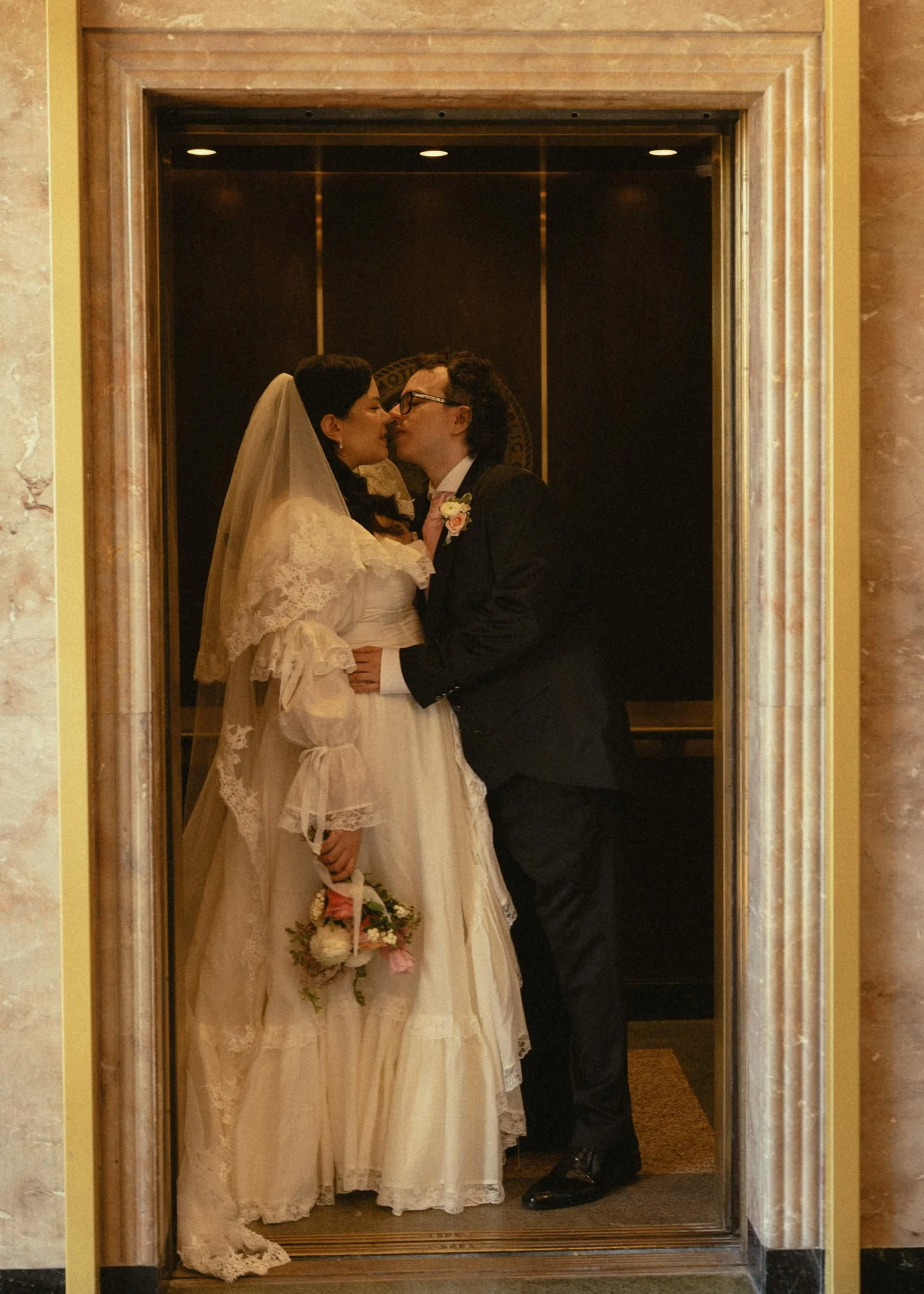 A quiet kiss together in the elevator on our wedding day